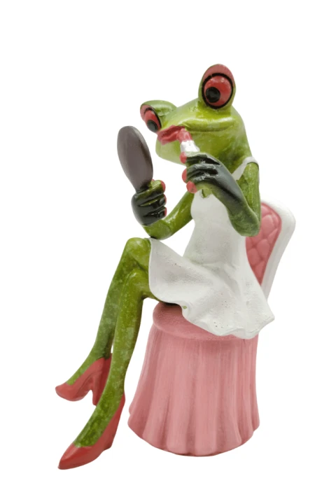 Figurka żaba w białej sukience robiąca makijaż.png