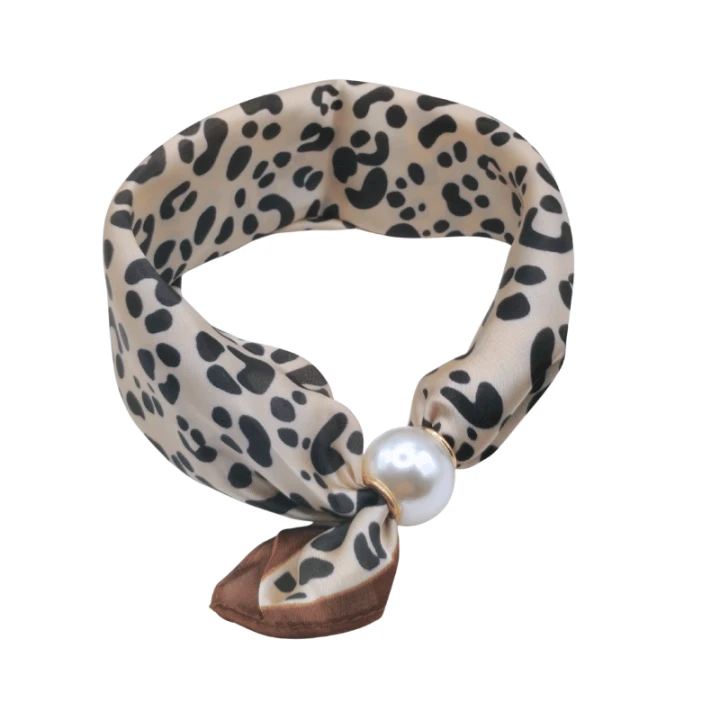 Scarf Necklace Pantera łączy elegancką apaszkę z ozdobną perłą, tworząc modny dodatek o wyjątkowym charakterze. Klasyczny wzór inspirowany panterką nadaje stylizacjom wyrazistości i ponadczasowej elegancji.
