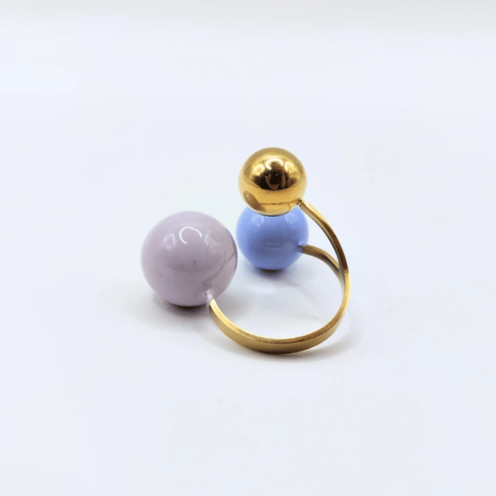 Minimalistyczny złoty pierścionek z pastelowymi kulami – modny dodatek do codziennych i eleganckich stylizacji.